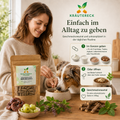 Tierärztin Mag. Sonja Steinegg mit Hund und Kräutereck ImmuBalance Kapsel-Packung in heller natürlicher Umgebung.